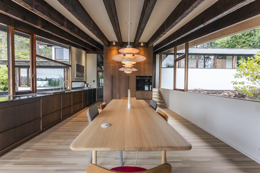 Long dining table aligned with the kitchen wall