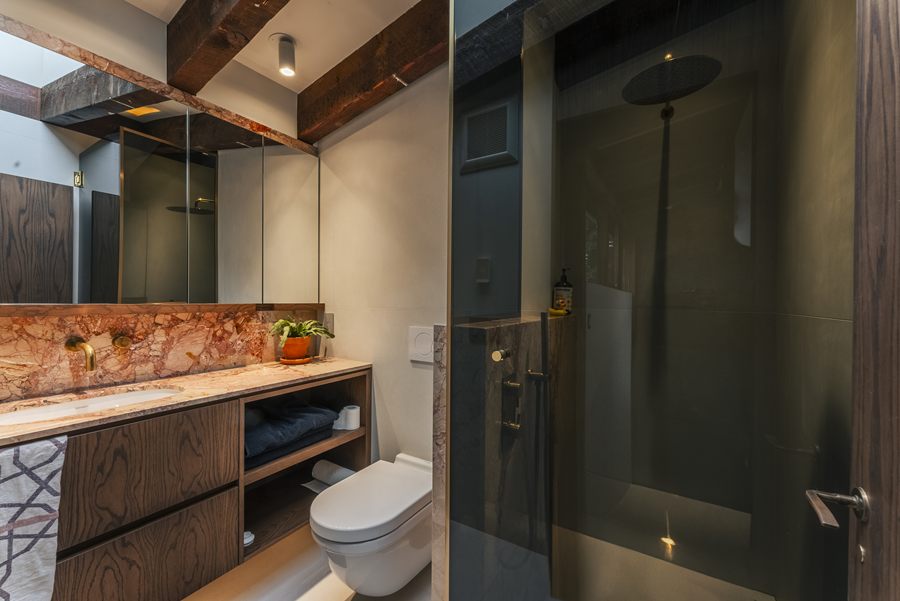 Bathroom with wood vanity and red stone backsplash