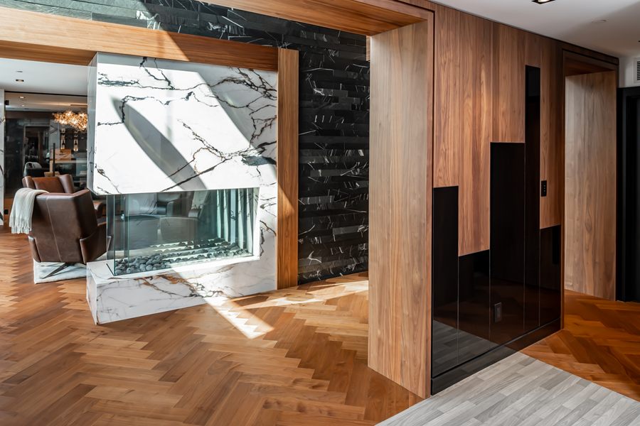 Oak wall panelling and millwork around a stone see-through fireplace