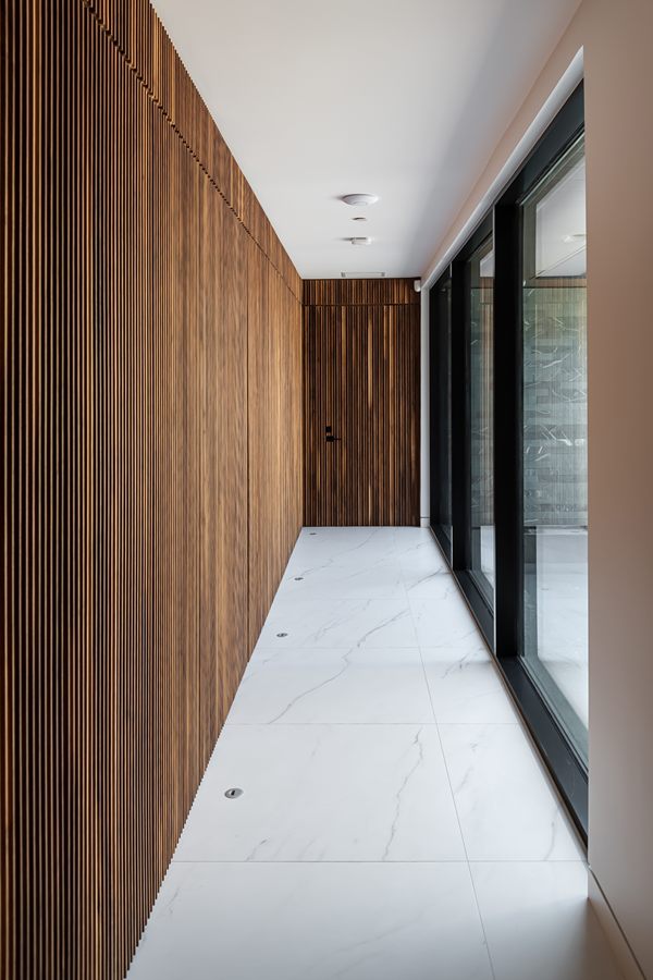 Corridor lined with slatted walnut panelling