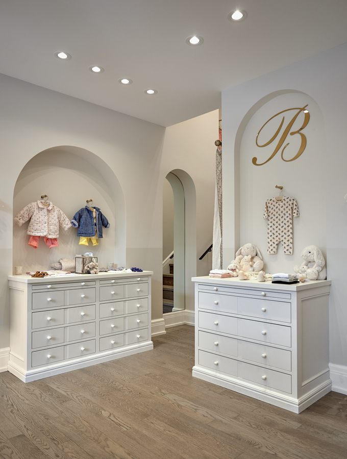 White painted dressers below a monogrammed arch