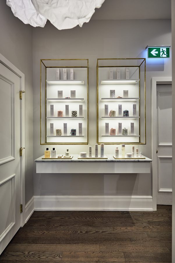 Brass-framed lit shelving above a floating counter