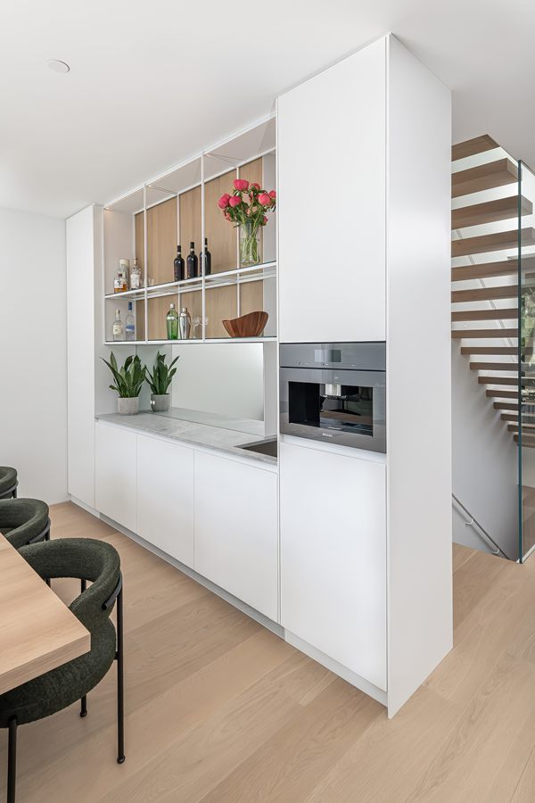 White kitchen wall with open oak shelving and built-in coffee station