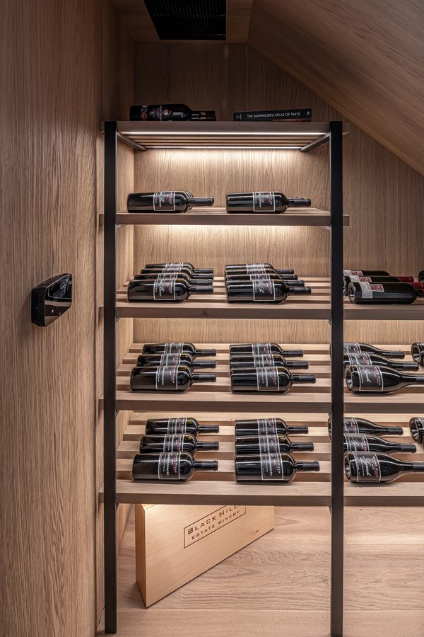 Wine room with lit oak and black shelving