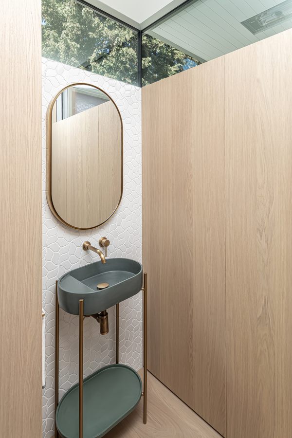 Powder room with an oval mirror set into oak panelling