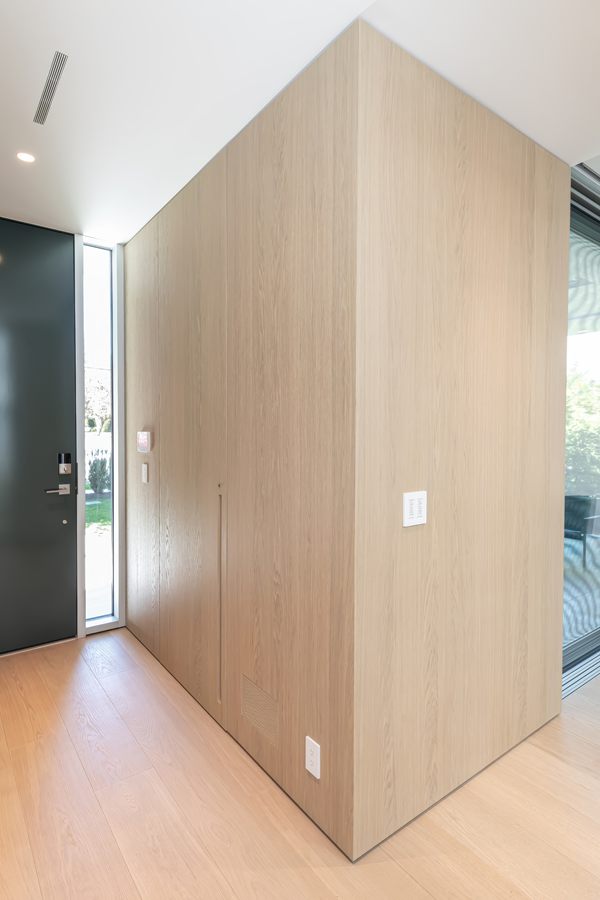 Entry with full-height white oak wall panelling