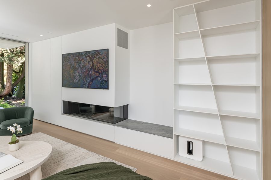 Built-in white shelving beside the fireplace wall