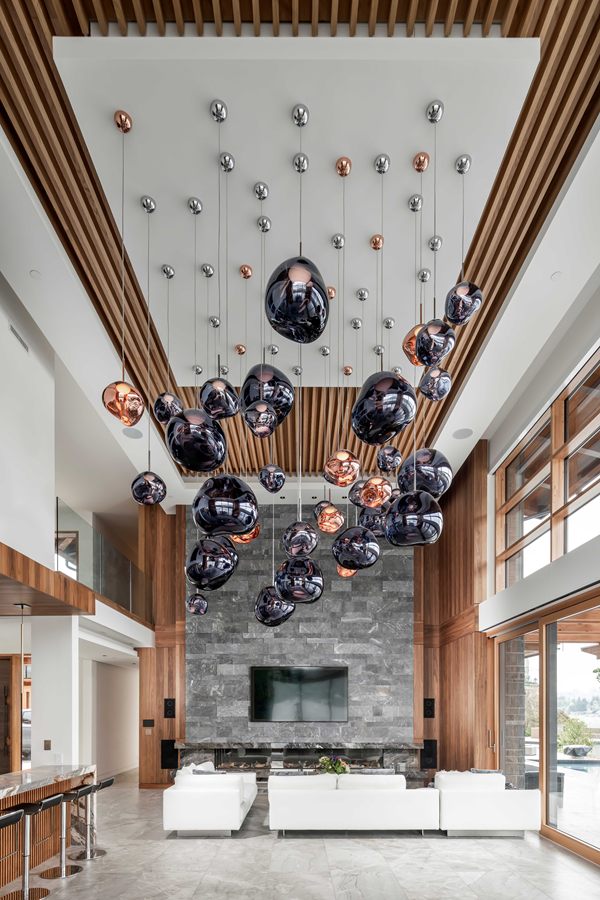 Glass pendant cluster hanging from a walnut-slatted ceiling
