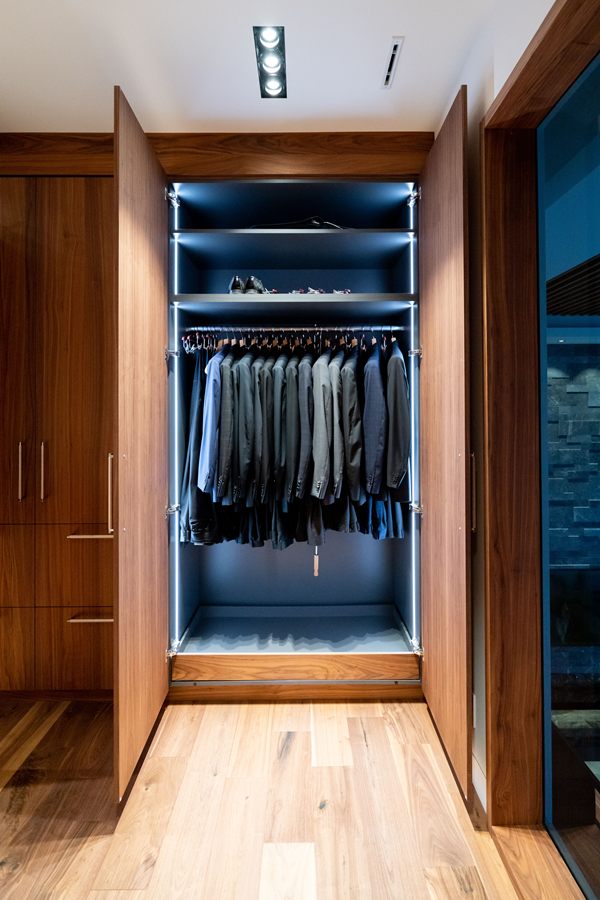 Walnut walk-in closet with lit hanging section