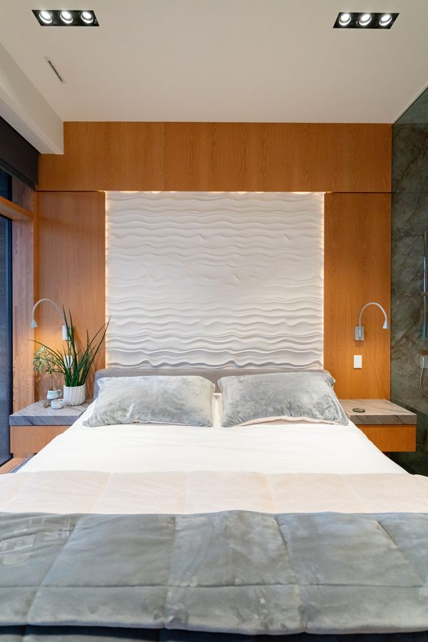 Bedroom with walnut headboard wall and floating night tables