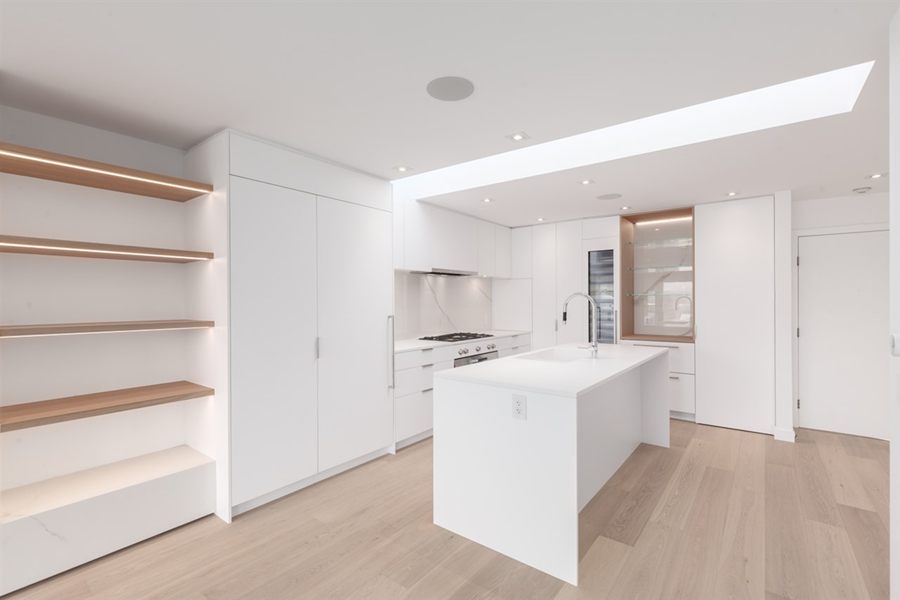 Open shelving with lit oak shelves beside the kitchen