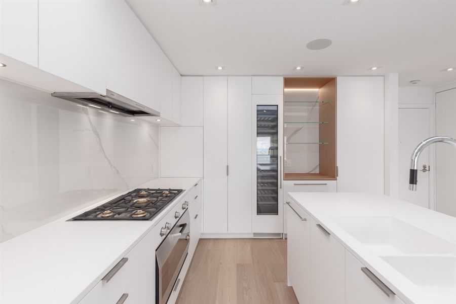 Kitchen with white cabinetry and a marble backsplash