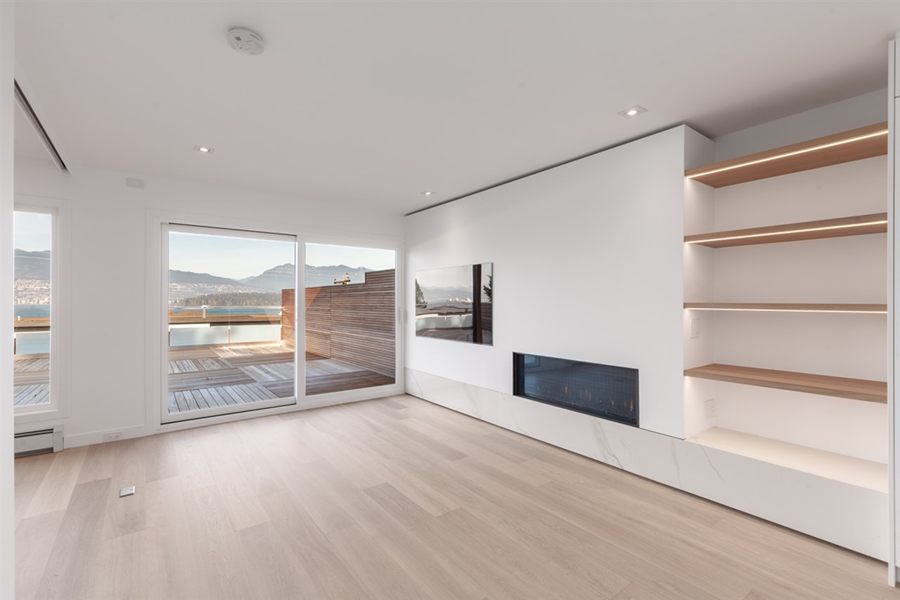 Living room with a long white media wall and oak shelving