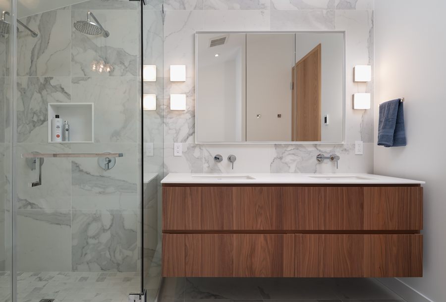 Ensuite with a floating walnut vanity and marble shower