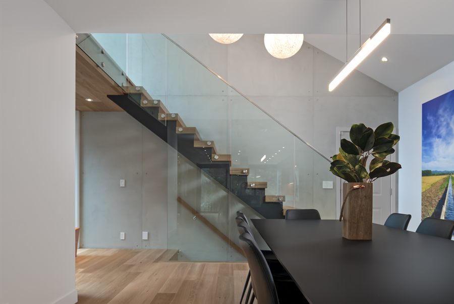 Open staircase with glass railing and globe pendants