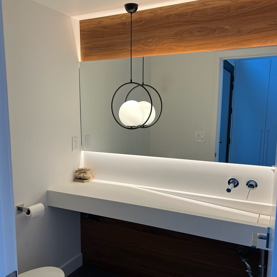 Floating white vanity with a lit wood soffit