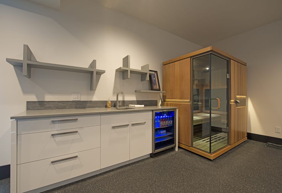 Gym bar with white cabinetry and a sauna