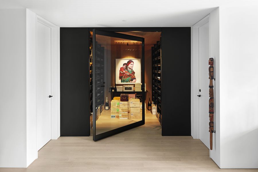 Pivot door opening into a lit wine and art room